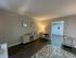 Inviting living space with elegant hardwood floors, modern decor, and cozy lighting, seamlessly connected to open kitchen area.