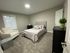 Inviting bedroom featuring a plush queen-sized bed, cozy armchair, and modern decor, creating a serene and comfortable retreat.
