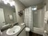 Modern bathroom with elegant fixtures, featuring a sleek vanity, contemporary lighting, and a stylish shower curtain.