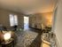 Inviting living room with modern decor, stylish glass coffee table, and cozy seating, featuring warm lighting and a chic workspace.