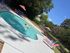 Inviting outdoor pool area with colorful lounge chairs and vibrant umbrellas, perfect for relaxation and enjoyment under a clear blue sky.