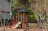Charming outdoor playground with vibrant red play structure, inviting slide, and lush greenery in a serene natural setting, perfect for family enjoyment.