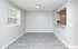 Bright apartment with sleek laminate flooring, large window, and open pass-through to the kitchen, perfect for modern living.