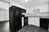 Modern black and white kitchen featuring sleek appliances, elegant cabinetry, and striking granite countertops.