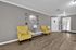 Chic living room with stylish yellow armchairs, elegant wall decor, and warm wooden flooring, exuding comfort and charm.
