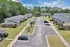 Charming apartment complex with spacious parking, surrounded by lush greenery and a peaceful atmosphere.