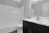 Modern bathroom featuring a sleek vanity, polished fixtures, and a pristine bathtub in an elegant setting.
