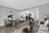 Modern living and dining area featuring sleek furniture, elegant decor, and an open layout with a view into a cozy kitchen.