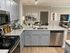 Modern kitchen with sleek granite countertops, stainless steel appliances, and inviting open layout flowing into a stylish living area.