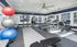 Bright and spacious gym with modern fitness equipment, large windows, and colorful exercise balls, perfect for energizing workouts.
