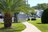 Inviting residential community with lush landscaping, palm tree, and convenient mailbox area along a well-maintained pathway.