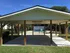 Charming covered pavilion overlooking a pristine pool area with lush greenery, perfect for outdoor gatherings.