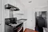 Modern kitchen with sleek black appliances, pristine white cabinetry, and polished countertops for a contemporary look.
