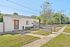 Charming brick home with a welcoming front entrance, lush greenery, and a spacious yard for outdoor enjoyment.