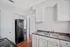 Modern kitchen featuring sleek black appliances, elegant white cabinetry, and polished wood flooring.