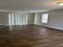 Spacious living room with elegant vinyl flooring and ample natural light from large windows.