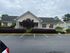 Charming single-story building with inviting front porch, welcoming balloons, and well-maintained landscaping.
