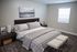 Elegant bedroom with a plush bed, modern nightstands, and chic decor in a tranquil setting.