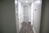 Bright and inviting hallway with elegant wood flooring, leading to a cozy room, ideal for a welcoming home atmosphere.
