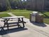 Inviting outdoor area with a sleek stainless steel grill and a classic picnic table, perfect for entertaining and enjoying sunny days.