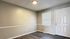 Bright and inviting room with modern wood flooring, neutral walls, and a large window offering natural light.