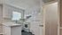 Charming kitchen with modern white cabinetry, sleek appliances, and a cozy countertop, bathed in natural light.