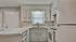 Charming kitchen with sleek white cabinets, modern appliances, and a stylish backsplash, offering a bright and inviting atmosphere.