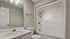 Modern bathroom with sleek white fixtures, elegant vanity, and a spacious shower bathtub combination, offering a clean and inviting atmosphere.