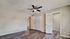 Bright and inviting bedroom with elegant wood flooring, spacious closet, and sleek ceiling fan.