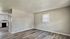 Bright and modern open space with sleek flooring, neutral walls, and adjacent kitchen, perfect for stylish living.
