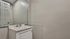 Modern minimalist bathroom with sleek white vanity and large mirror, offering a clean and sophisticated space.