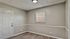 Inviting room with modern wood flooring, elegant trim, and a bright window welcoming natural light.