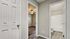 Bright hallway featuring elegant wood flooring leading to a cozy bedroom and modern bathroom, highlighting contemporary design and warm ambiance.
