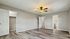 Spacious bedroom with modern flooring, ceiling fan, and en-suite bathroom access, ideal for comfort and style.