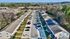 Charming suburban apartment complex with modern style, ample parking, and lush green surroundings.