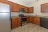 Modern kitchen with stainless steel appliances, elegant granite countertops, and warm wooden cabinetry.