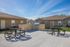 Inviting outdoor space with modern grill area, perfect for entertaining, surrounded by charming residences and clear blue skies.