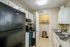Charming kitchen with modern black appliances, inviting decor, and convenient access to a well-organized laundry room. Ideal blend of style and functionality for effortless living.