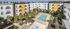 Modern apartment complex featuring vibrant architecture, lush palm-lined courtyard, and inviting outdoor pool area.