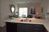 Bright and welcoming kitchen and living area featuring a sleek countertop with a modern sink, elegant decor, and stylish seating by large windows inviting natural light.