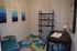 Cozy and stylish home office with modern abstract art, elegant d&eacute;cor on shelving, and a vibrant patterned rug, perfect for inspiration and productivity.