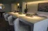 Chic modern kitchen with sleek marble countertops, elegant bar stools, and stylish greenery accents.