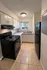 Charming kitchen with sleek black appliances, modern cabinetry, and a sunlit window for a fresh, inviting space.