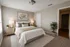 Inviting bedroom featuring a cozy bed with chic pillows, soft lighting, and decorative plants creating a serene and stylish ambiance.