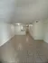 Spacious apartment interior featuring elegant tile flooring, neutral walls, and recessed lighting, offering a blank canvas for stylish d&eacute;cor.