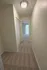 Inviting hallway with plush carpet leading to a bright room, featuring elegant closet doors and modern lighting.
