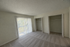 Bright, spacious bedroom with large closets and sliding glass doors leading to a sunny balcony.