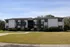 Charming two-story apartment complex with lush landscaping and private balconies, offering a tranquil living experience.