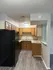 Charming kitchen with sleek black appliances, updated wood cabinetry, and inviting wood-style flooring.