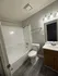 Modern bathroom with sleek fixtures, elegant vanity, and spacious bathtub, ideal for relaxation.